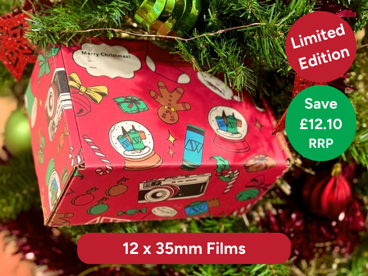 Red gift box with Christmas-themed design on a tree, featuring promotional text of 12x 35mm films, Limited Edition and Save £12.10 RRP.
