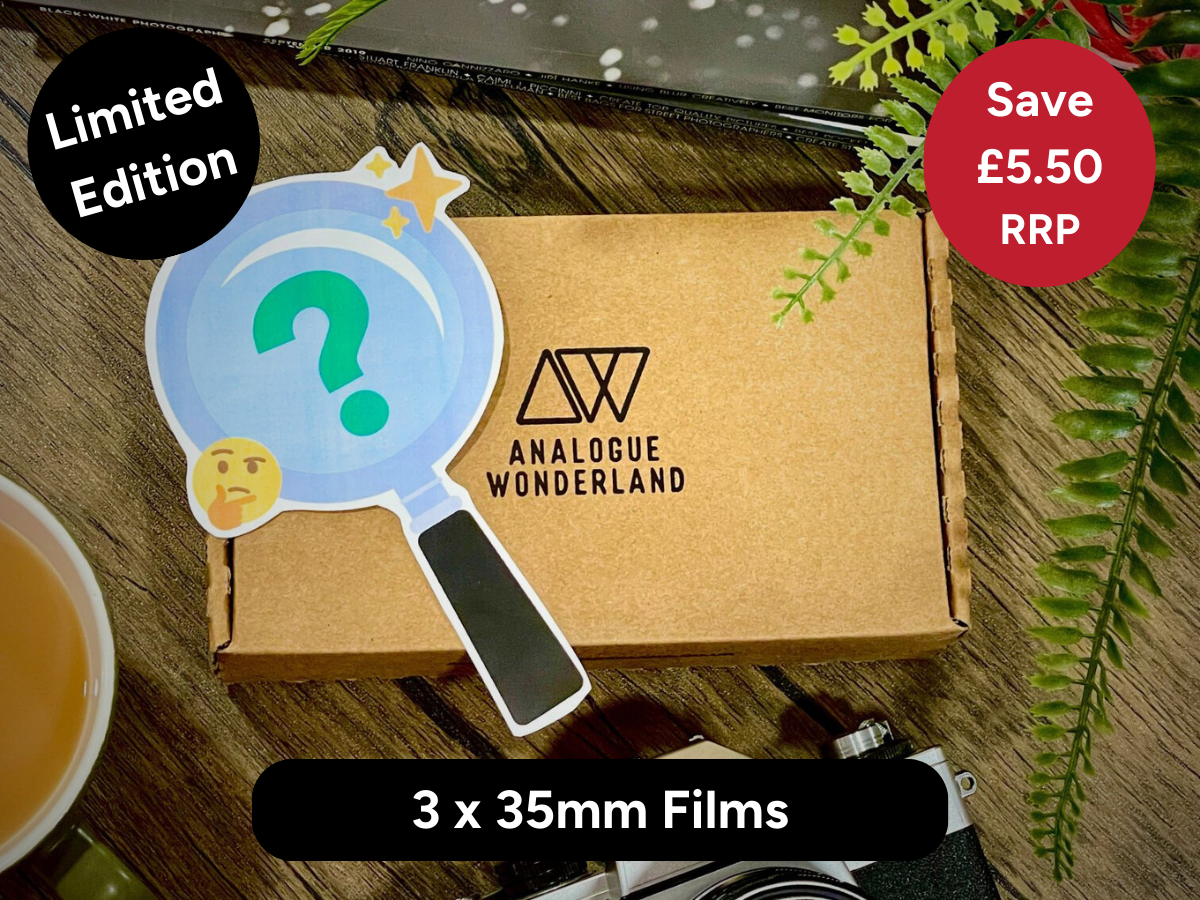 Brown box with 'Analogue Wonderland' logo featuring a magnifying glass with a question mark on a wooden surface.