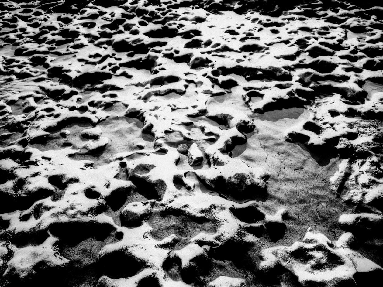 Close-up of textured sand with footprints.
