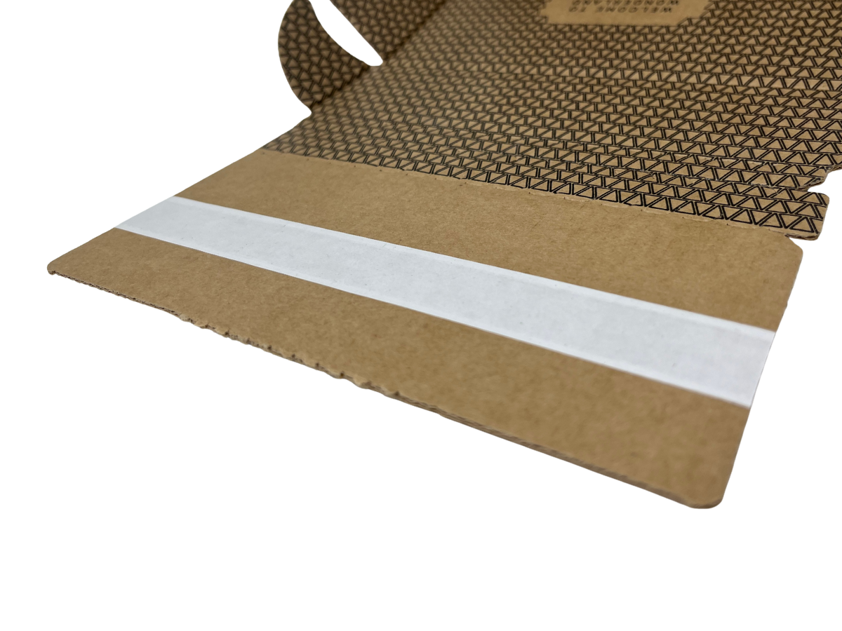 A close-up of a brown kraft cardboard shipping box with a textured patterned interior and a white adhesive strip along the flap, shown on a white background.