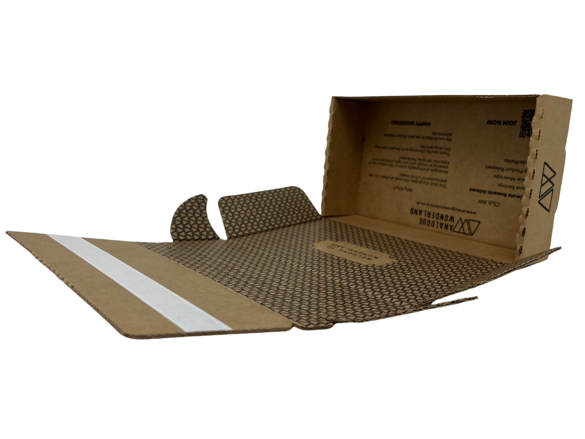 An open brown corrugated cardboard box with a honeycomb pattern on the interior, a white stripe on the flap, and printed text and logos on the inside walls, shown on a white background.