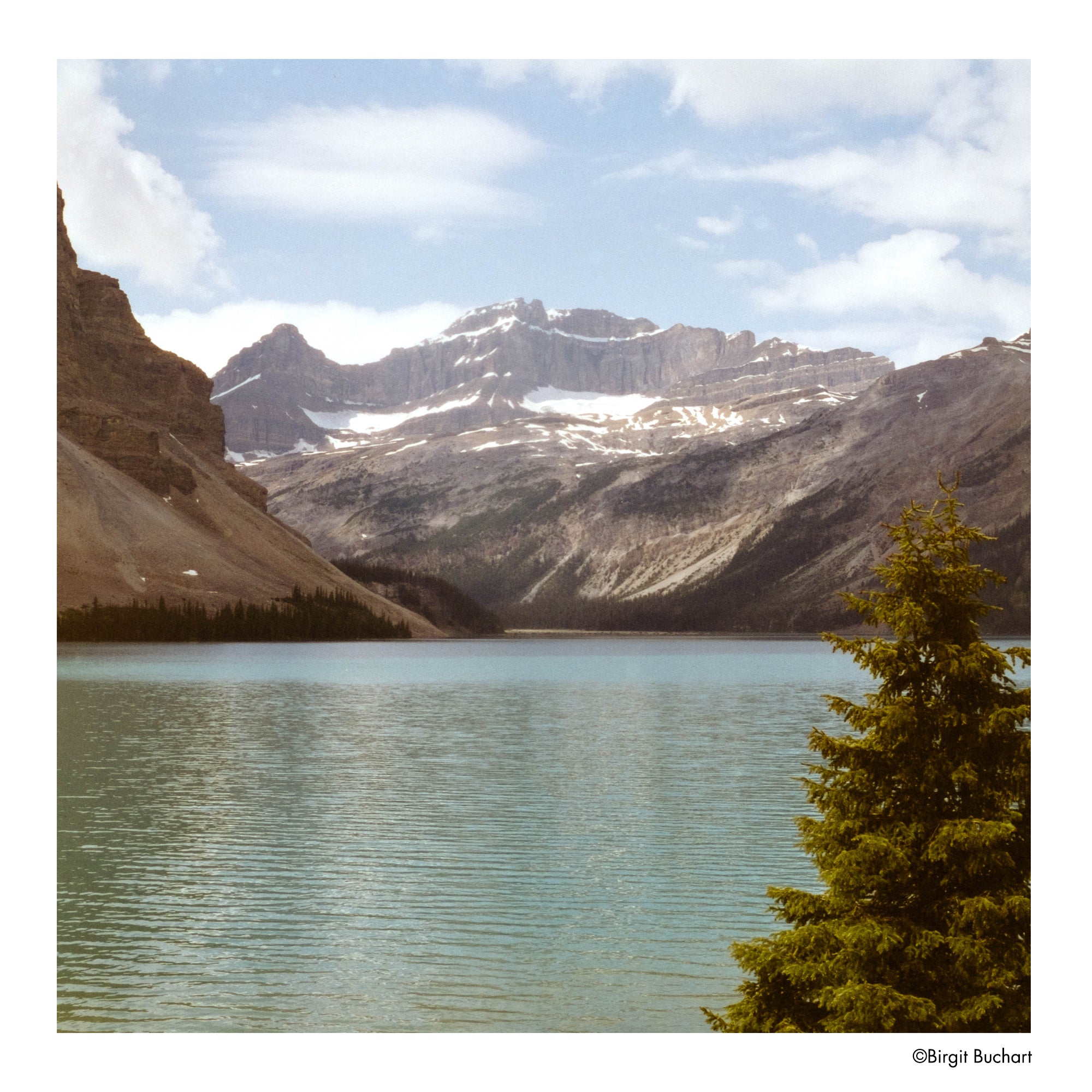 Lake with mountains in the background under a blue sky with clouds- shot on Harman Phoenix II 120 film