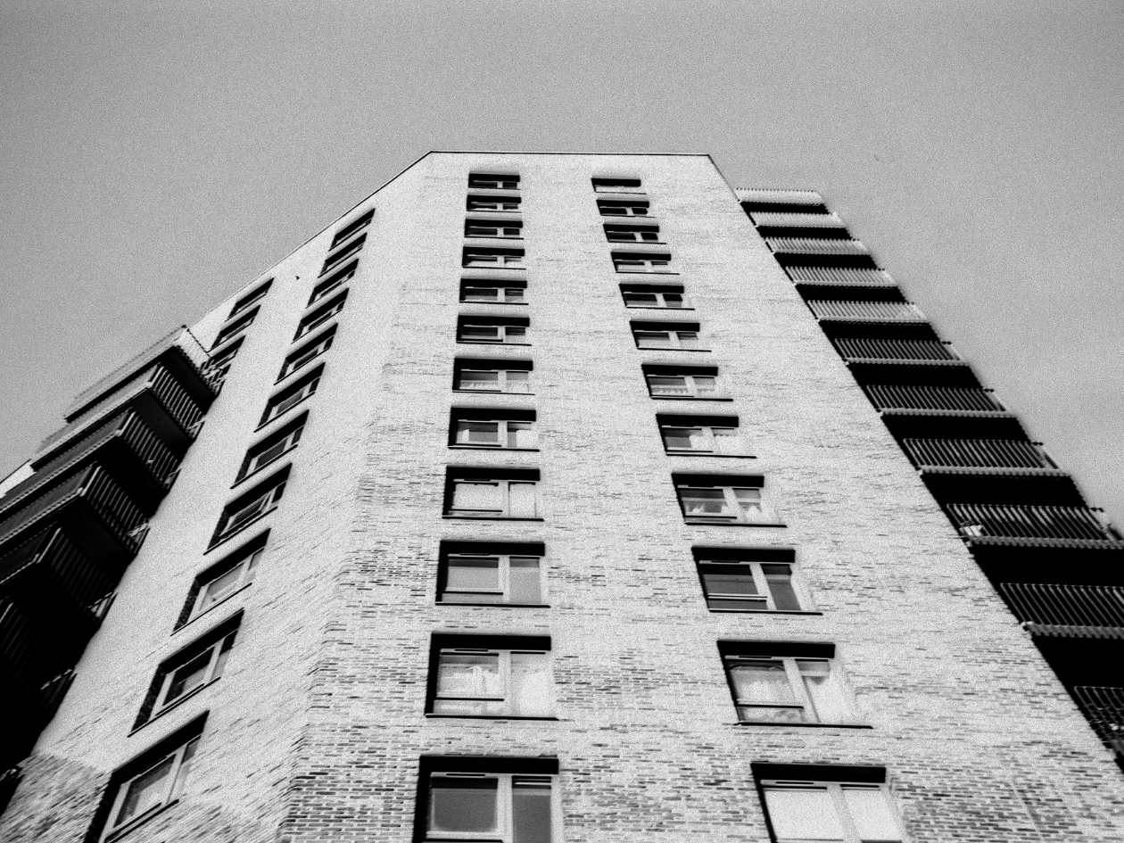 Black and white photo of a tall brick building.