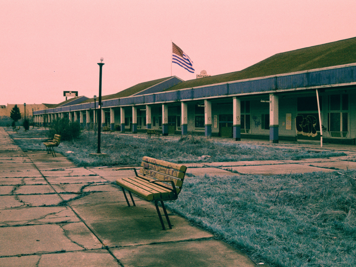 Sample shots (c) Trev Lee. Graffiti on bench outside building with USA flag flying.