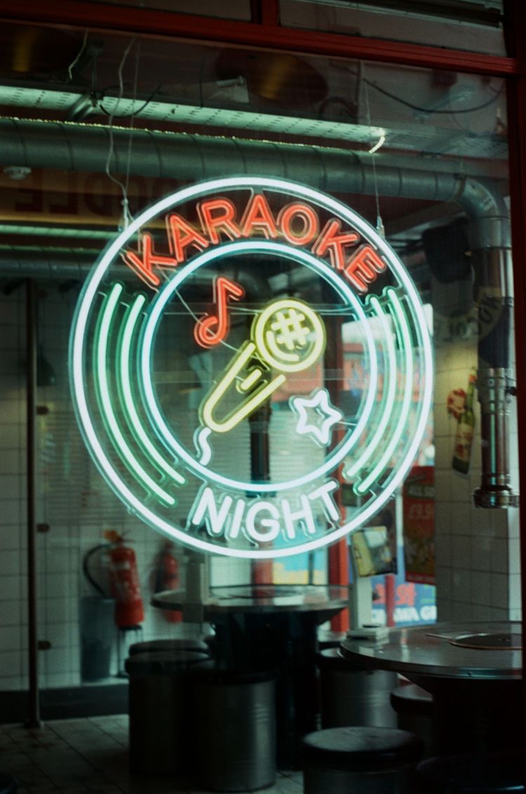 Neon sign advertising 'Karaoke Night' with a microphone graphic. Taken on Mr Negative Secret Sauce 35mm Film by Azucena Morales.