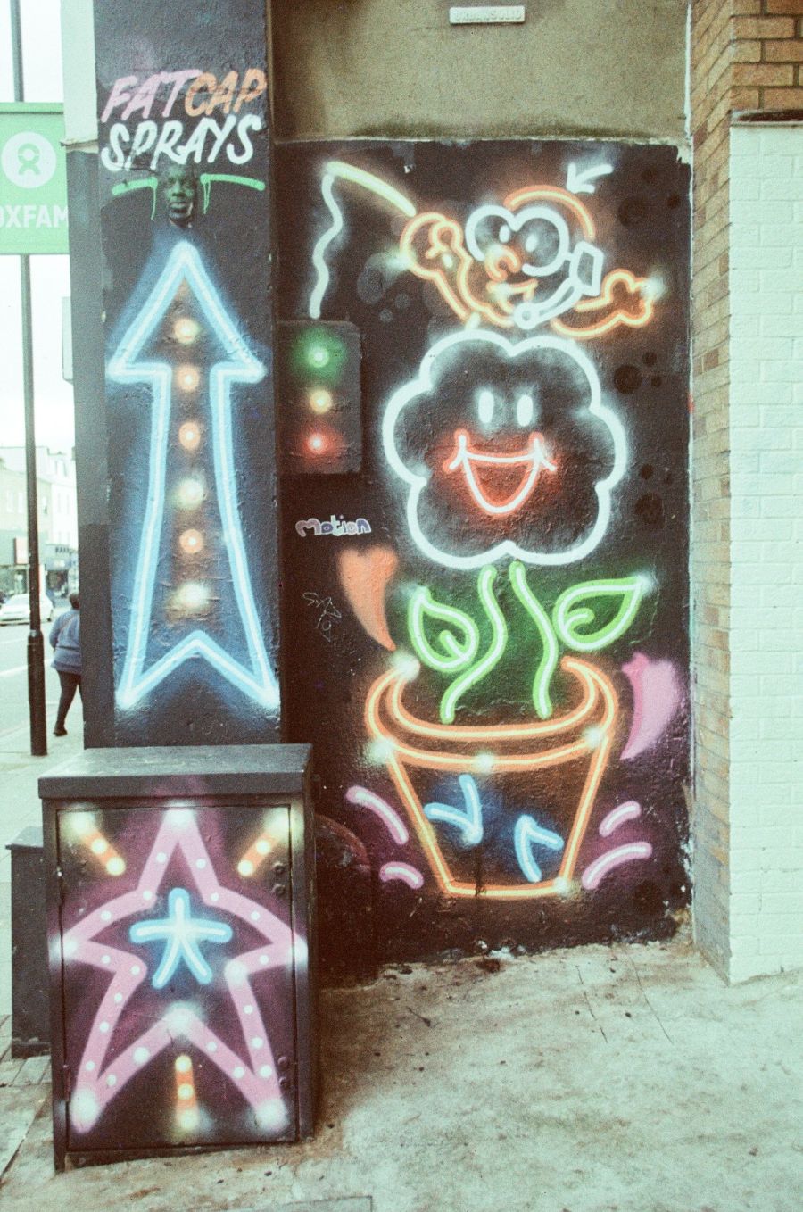 Neon signs on a wall with 'Fatcap Sprays' branding.