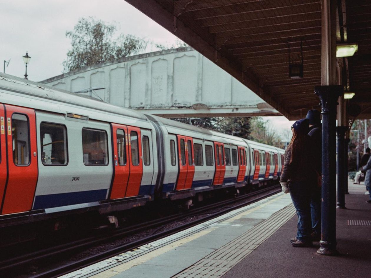 Train at a station platform with a person waiting.