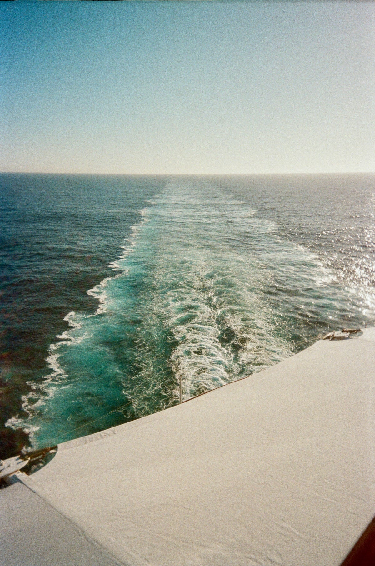 Sample photo for the Kodak EC35 film camera. A scenic photograph of a ship's wake cutting through deep blue ocean water under a clear sky, with the edge of a white deck or canopy visible in the foreground.