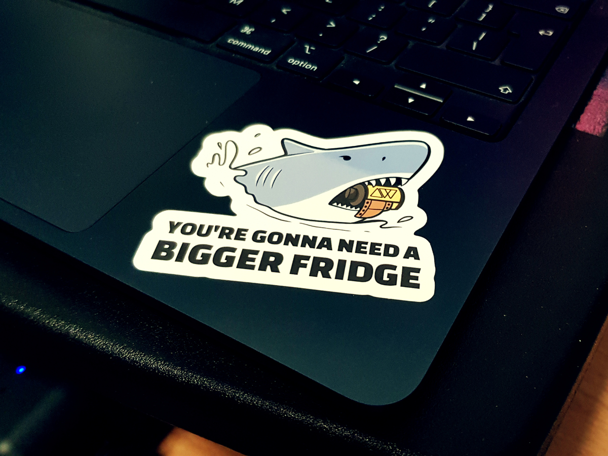 Sticker on a laptop screen with text 'You're gonna need a bigger fridge' and a shark graphic.
