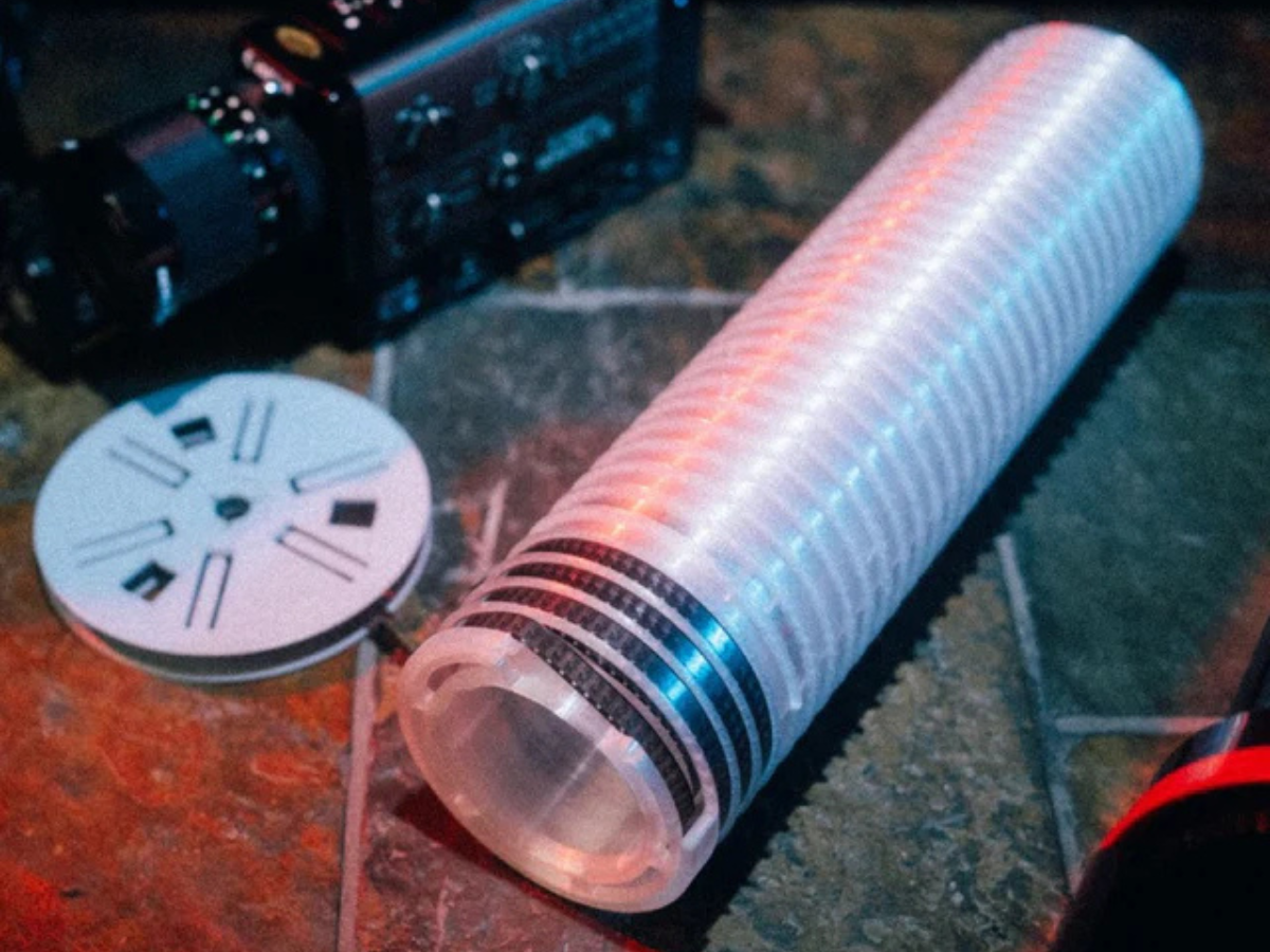 Super 8 Developing Reel with red and blue lights on a dark surface