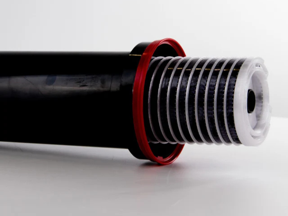 Close-up of a Paterson development tank and the Super 8 Developing Reel on a light grey background