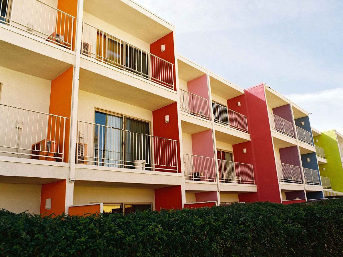 Colorful apartment building with balconies against a blue sky.