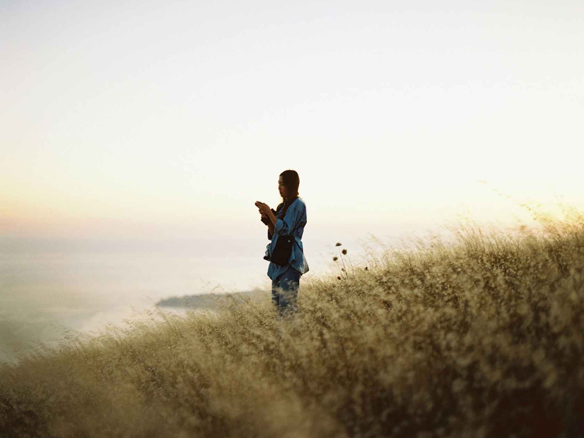 Person standing in tall grass with a blurred background