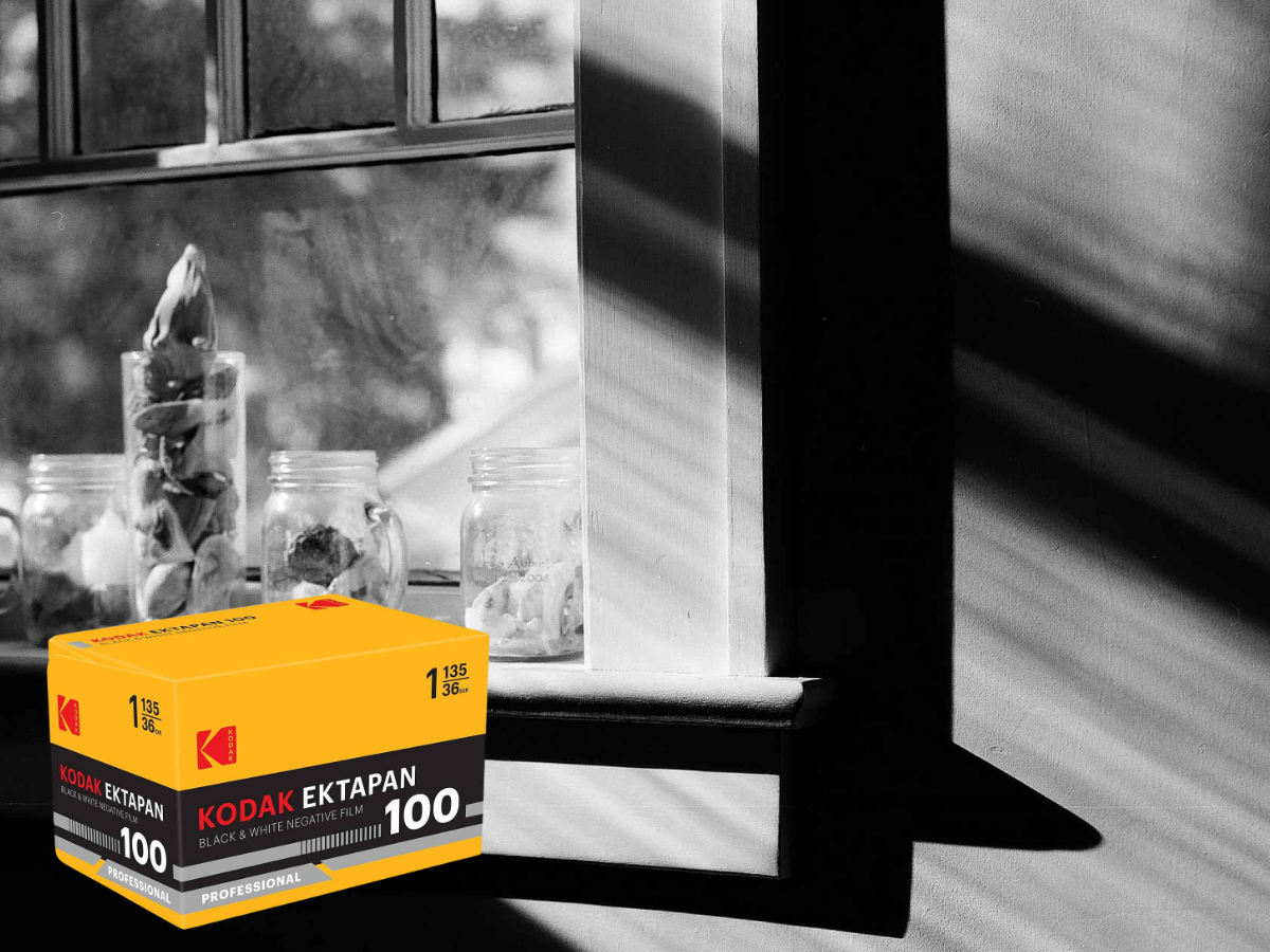 Kodak Ektapan 100 film box in front of a window with jars on a windowsill.