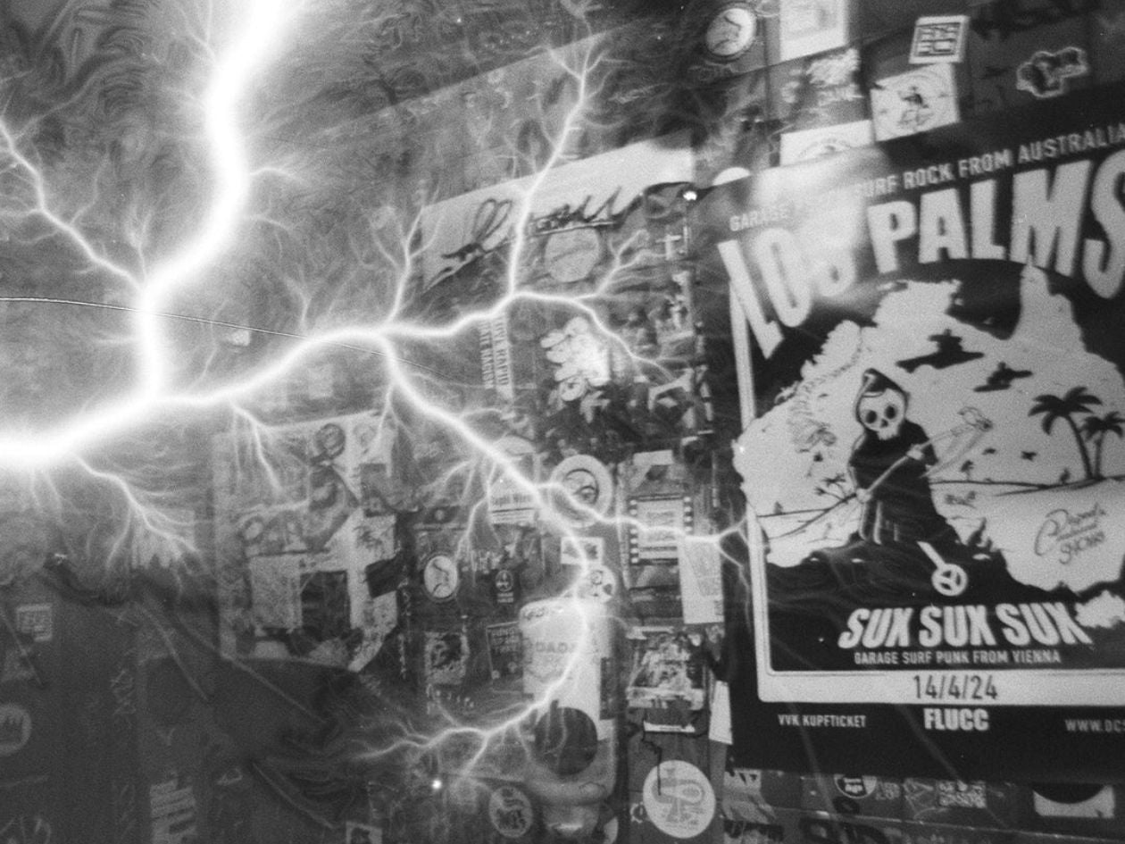 A collage of posters and stickers overlaid with bright lightning streaks in a black-and-white photo.